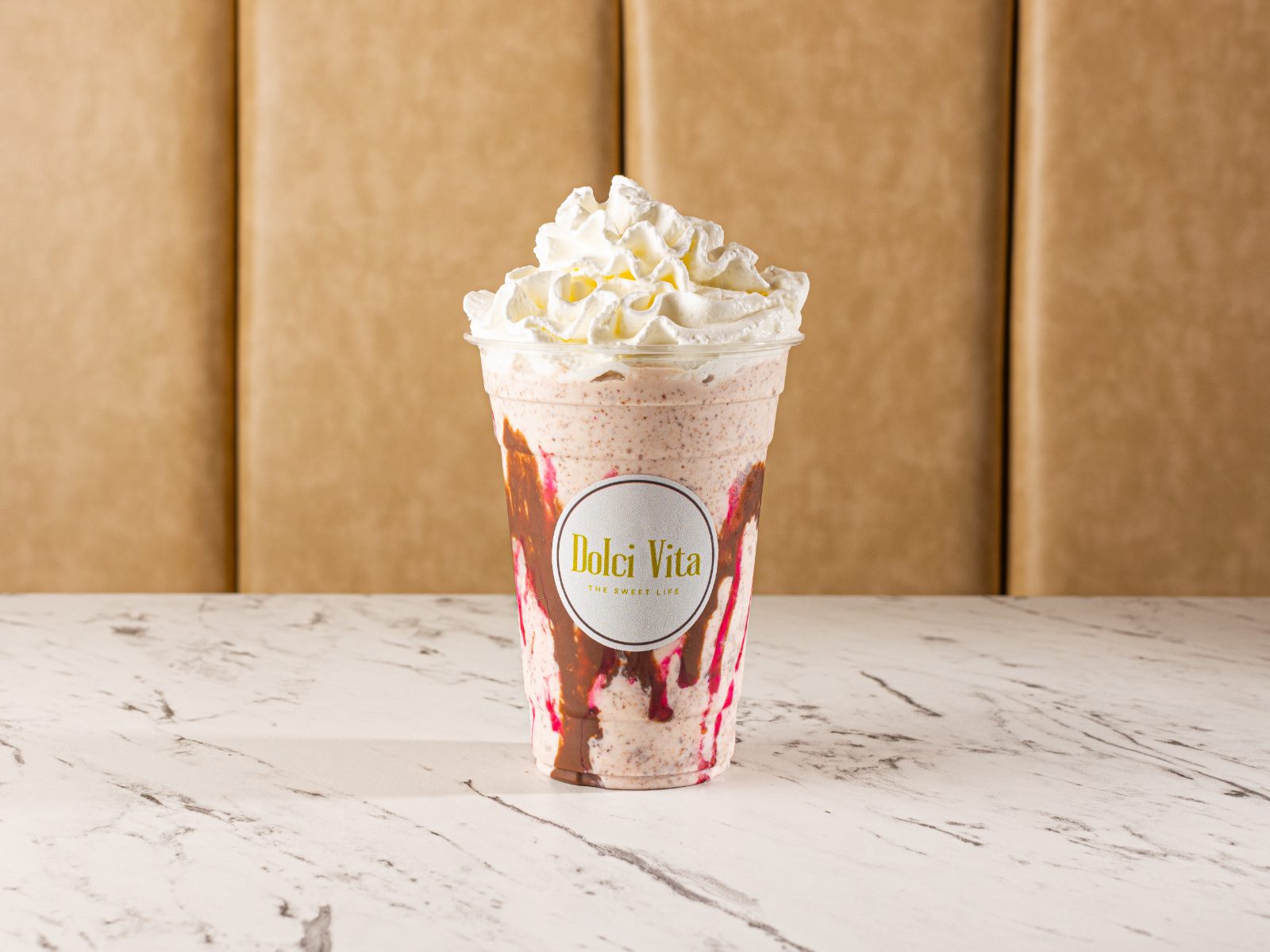 Strawberry milkshake with whipped cream and berry drizzle